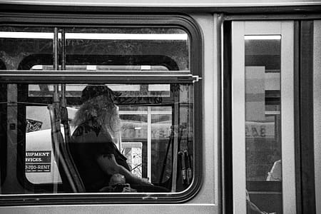 Grayscale Photography of Man Sitting Inside Bus thumbnail