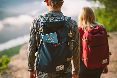 blue book inside man's blue backpack thumbnail