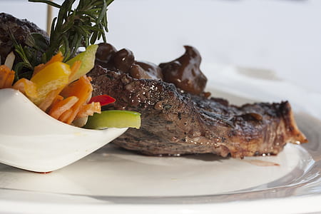 grilled meat on plate beside sliced vegetable thumbnail