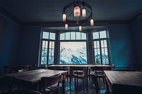 brown wooden table with chairs set beside white wall thumbnail