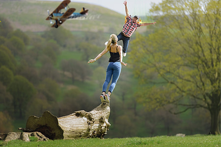 man and woman on a tree trunk during day time thumbnail