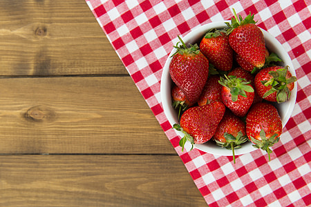 Bowl of strawberries on a wood table thumbnail