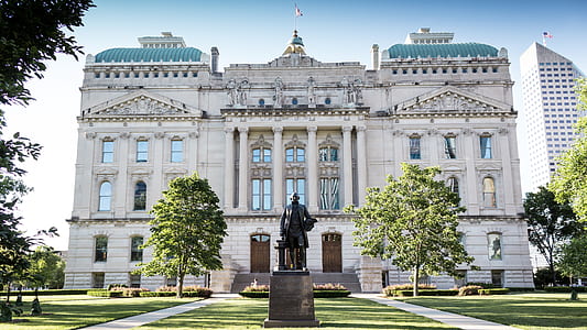 man statue on front of white building thumbnail
