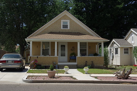 grey vehicle parked near yellow painted house during daytime thumbnail