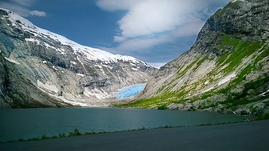 mountain with body of water under blue sky thumbnail