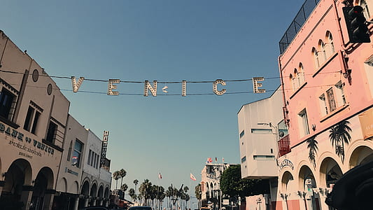 Venice free standing letter between concrete houses under blue sky at daytime thumbnail