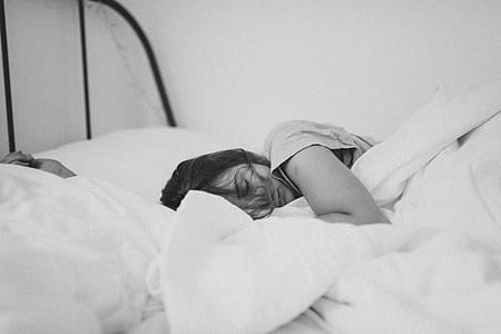 grayscale photography of person sleeping on bed thumbnail