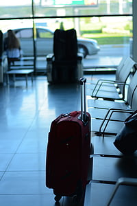 red travel luggage near gang chair thumbnail