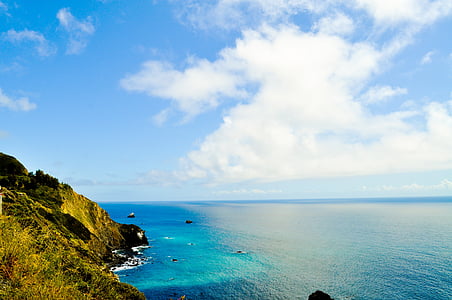 sea near mountain under clouds at daytime thumbnail