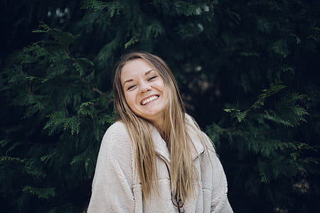 woman smiling in front of green plants thumbnail