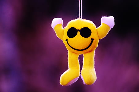 selective focus photography of hanging yellow emoji plush toy thumbnail