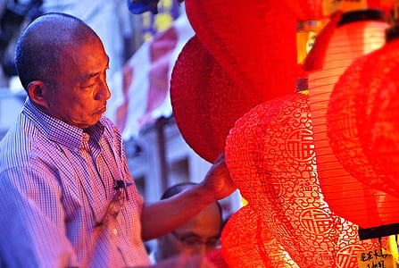 man standing beside paper lanterns thumbnail