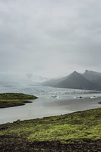 aerial photography of mountains and lake under white clouds at daytime thumbnail