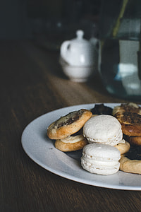 assorted cookies in white ceramic plate on brown wooden tabletop thumbnail