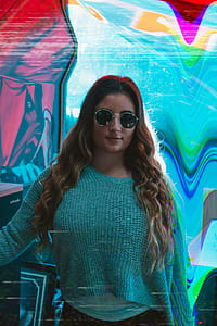 woman wearing sunglasses and knit crew-neck long-sleeved shirt standing near the wall thumbnail