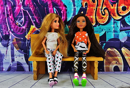 two women dolls sitting on brown wooden bench thumbnail