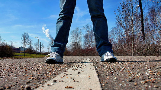 person standing in the middle of the road during daytime thumbnail