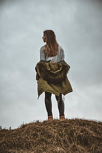 woman wearing beige parka hoodie standing on mountain thumbnail