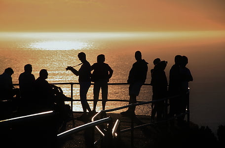 silhouette photography of people near body of water during daytime thumbnail