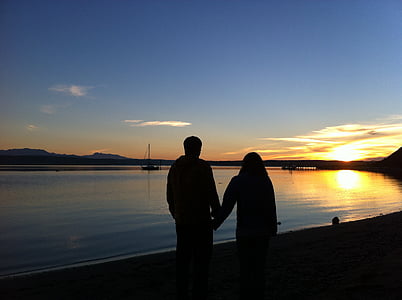 silhouette of couple holding hands standing on seashore during daytimne thumbnail