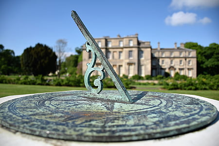 gray sun dial near gray building thumbnail