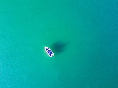bird's eye view of a boat on wide body of water thumbnail