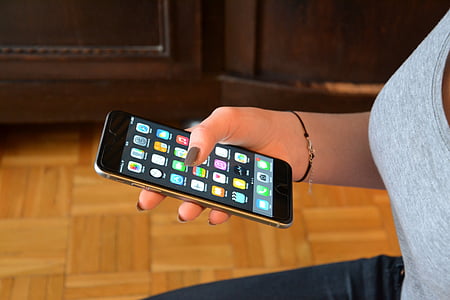 woman holding turned-on space gray iPhone 6 thumbnail