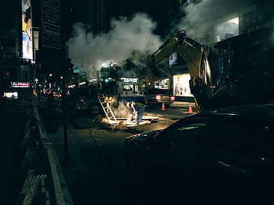 yellow front-loader on asphalt road during night thumbnail