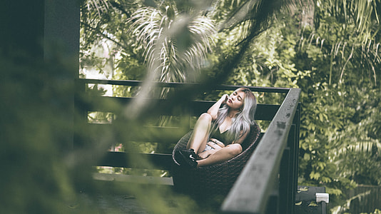 woman wearing green sleeveless top across woods thumbnail
