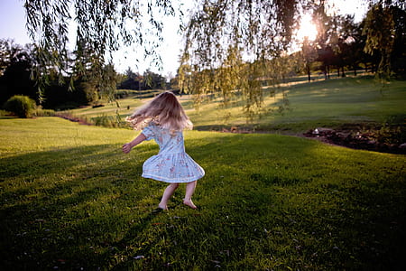 girl standing on grass field under tree thumbnail