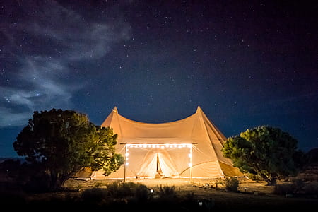 brown tent with string lights surrounded by trees thumbnail
