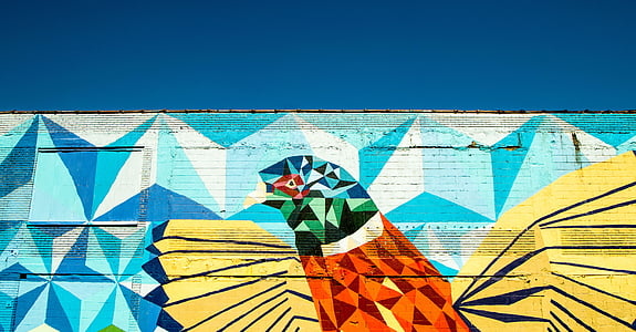 red and yellow bird graffiti under blue sky thumbnail