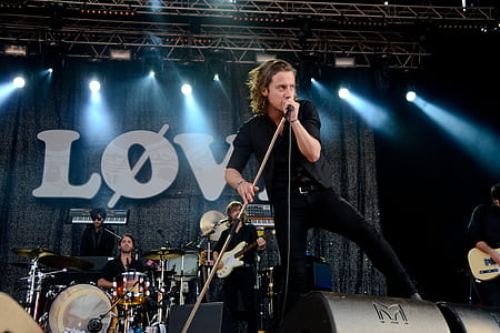 Person Holding a Microphone While Singing at Stage thumbnail