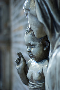 woman holding baby statue during daytime thumbnail
