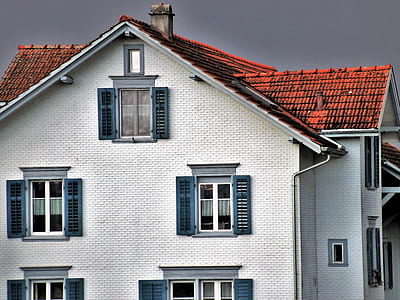 white and brown 3-storey house under dramatic sky thumbnail