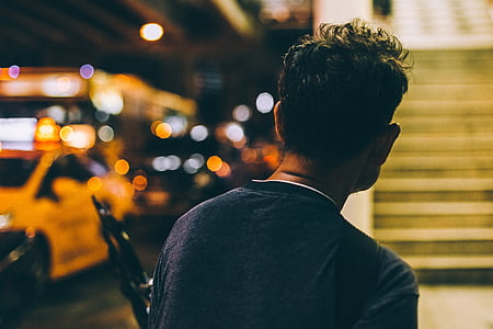 man standing on street near car thumbnail
