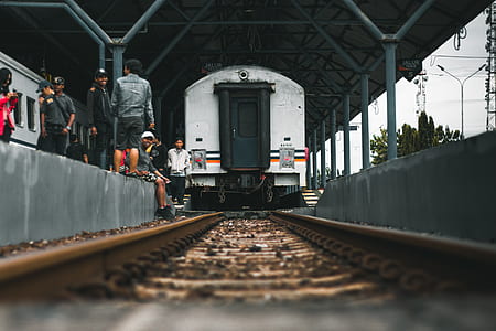 people sitting near railway and train thumbnail