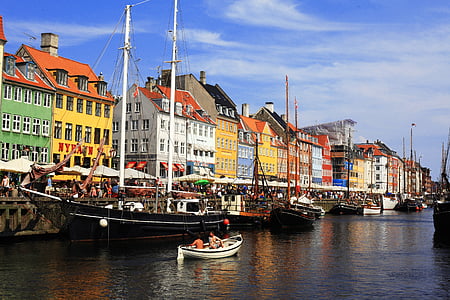 ships parked on banks near multicolored houses at daytime thumbnail