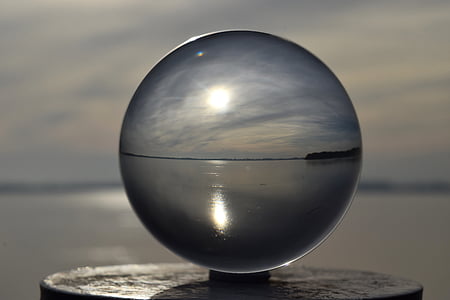 glass ball photography of sea under white clouds thumbnail