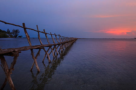 body of water with wooden bridge at daytime thumbnail