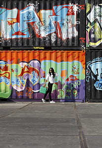 woman standing near intermodal grafiti containers thumbnail