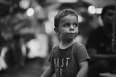 grayscale selective focus photography of boy wearing crew-neck t-shirt thumbnail