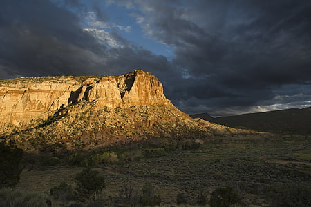 brown rock monolith under gray clouds thumbnail