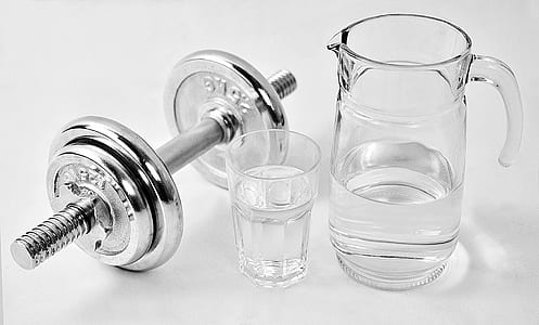 close-up photo of clear pitcher beside drinking glass and dumbbell thumbnail