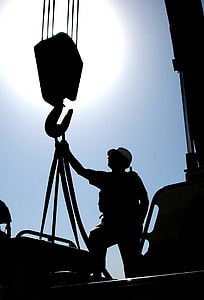 silhouette of man standing near crane hook thumbnail