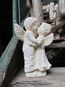 kissing angel statue on brown wooden surface thumbnail