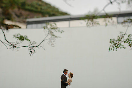 couple standing near wall embracing each other thumbnail