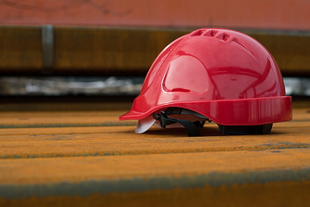 red plastic hard hat on brown surface thumbnail