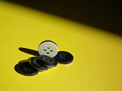 close-up photo of black and white buttons on yellow suface thumbnail