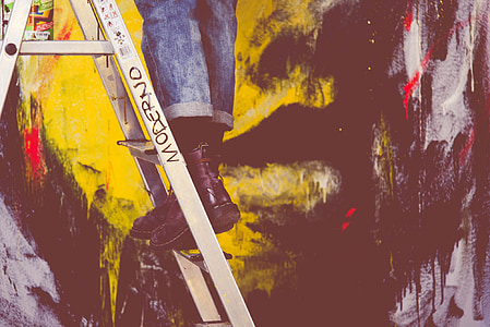 person on gray metal A-frame ladder thumbnail